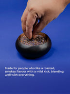 Hand reaching into a small black container filled with smoothmix Blue herbal smoking pack on a blue background